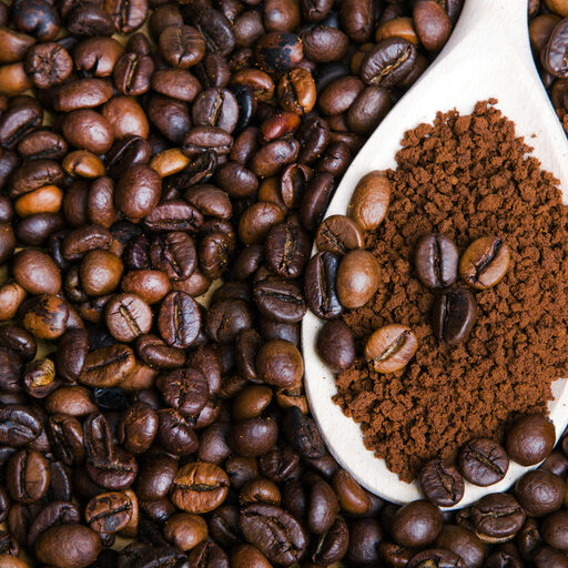 Iinstant coffee in spoon on coffee beans background